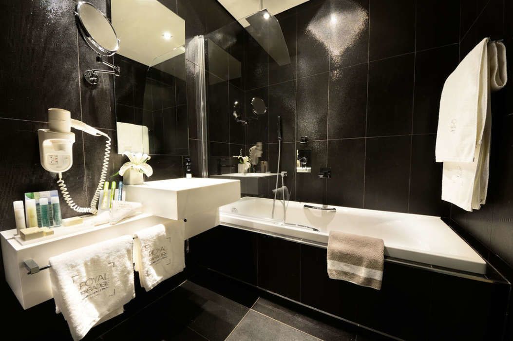 Un baño moderno con una bañera grande, una zona de ducha separada y un tocador con espejo y toallero.