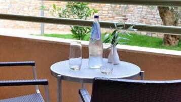 A round table with two chairs, a water bottle, and a glass on it.