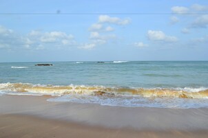 Una playa con cielo despejado y mar tranquilo.