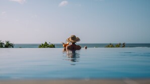 Una persona en una piscina con vista al océano.