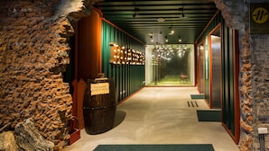 A hallway with a brick wall, wooden barrel, and green-striped walls. - Roaders Hotel Zhonghua (Taipei)