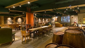 A cozy restaurant with wooden tables, chairs, and barrels. - Roaders Hotel Zhonghua (Taipei)