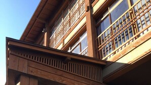 A traditional wooden building with a covered entrance and large windows. - YUBANA MANKAI (Higashiizu)