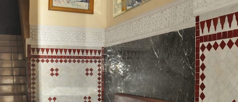 Une pièce avec un canapé, une table et un mur décoré de motifs.