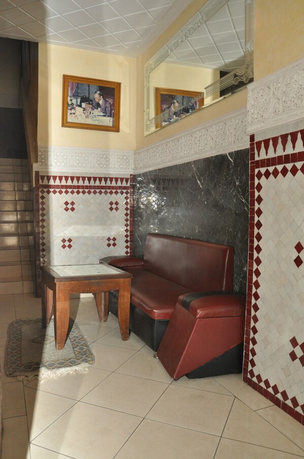 A room with a sofa, a table, and a patterned wall.