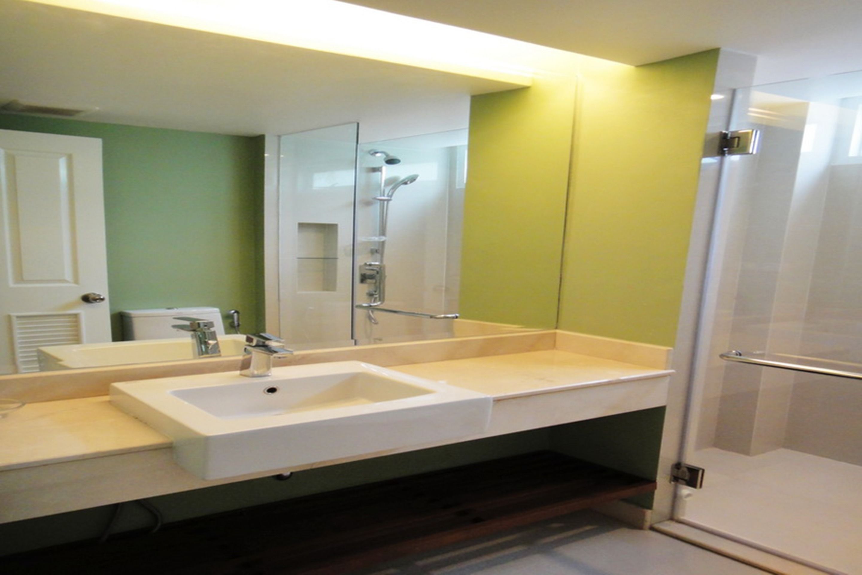 A bathroom with a white sink, a mirror, and a shower.