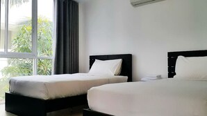A hotel room with two beds, a large window with curtains, and an air conditioning unit on the wall. - Chan Residence Hua Hin (Hua Hin)