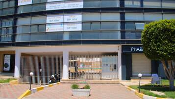Un edifici amb diversos comerços, incloent les inscripcions 'A VENDRE' i 'SUP 154m²'.