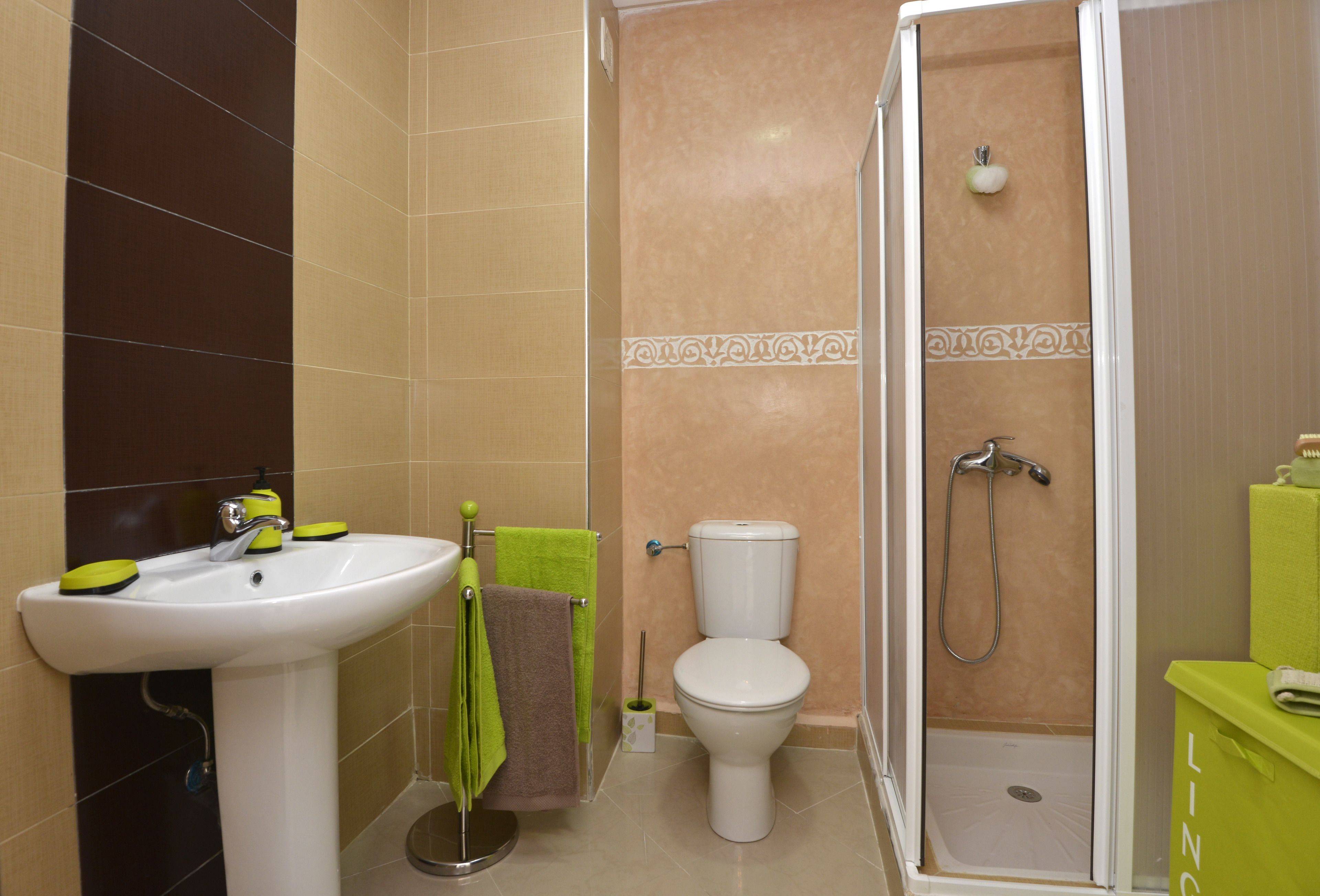Un baño con lavamanos, inodoro y ducha.