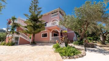 Stroll through the serene courtyard, surrounded by lush greenery and a decorative tree stump.
