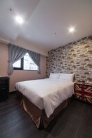 Een slaapkamer met een bed, een kaptafel, een koffer en een muur met een baksteenmotief.