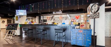 A bar area with a counter, stools, a clock, and a calendar.