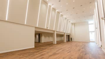Ein großzügiges, modernes Interieur mit Holzboden, weißen Wänden und einer hohen Decke mit eingelassener Beleuchtung.