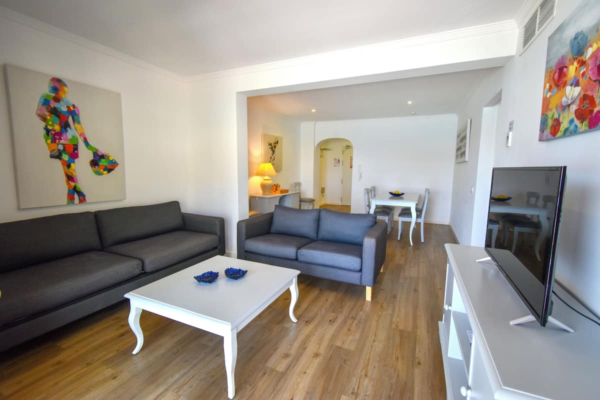 A modern living room with two sofas, a white coffee table, and a flat-screen TV.