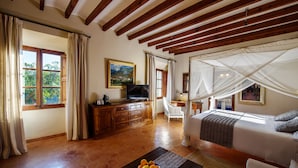 A bedroom with a bed, a television, a desk, and a chair.