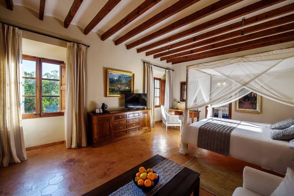A bedroom with a bed, a television, a desk, and a chair.