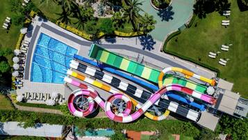 Relax by the pool surrounded by lush greenery and palm trees, or enjoy a thrilling water slide experience.