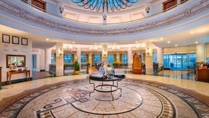 A grand lobby with a circular mosaic floor, a central table, and a chandelier. - Trendy Aspendos Beach - All Inclusive (Manavgat)