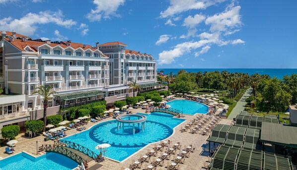 Un resort con varias piscinas, una zona techada y vista al océano.
