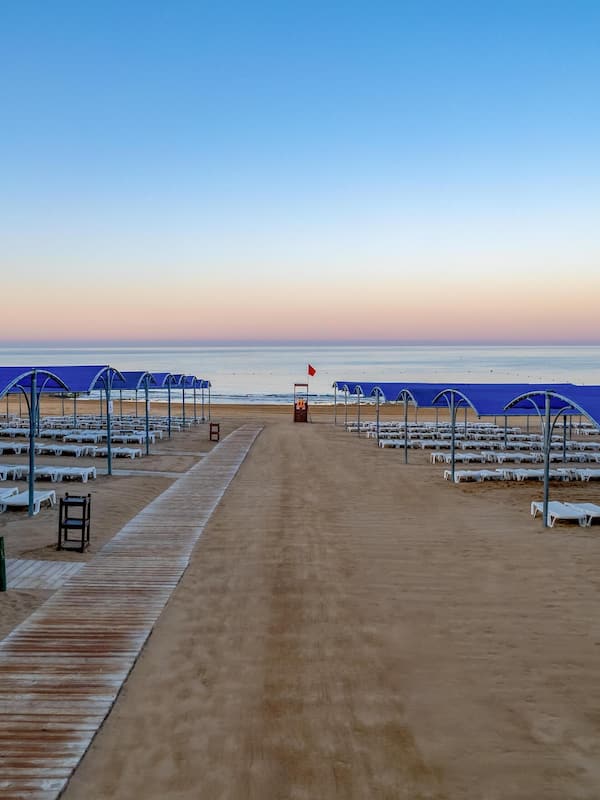 Praia particular, espreguiçadeiras, guarda-sóis, toalhas de praia