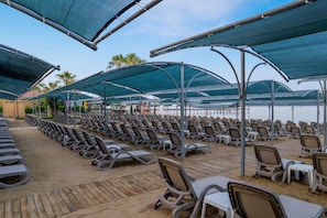 Aan een privéstrand, ligstoelen, parasols, strandlakens