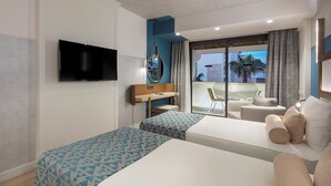 A modern hotel room with a flat-screen TV mounted on the wall, a balcony with a view, and a seating area with a sofa and armchairs. - Trendy Side Beach (Adults Only, 16+) - All inclusive (Manavgat)