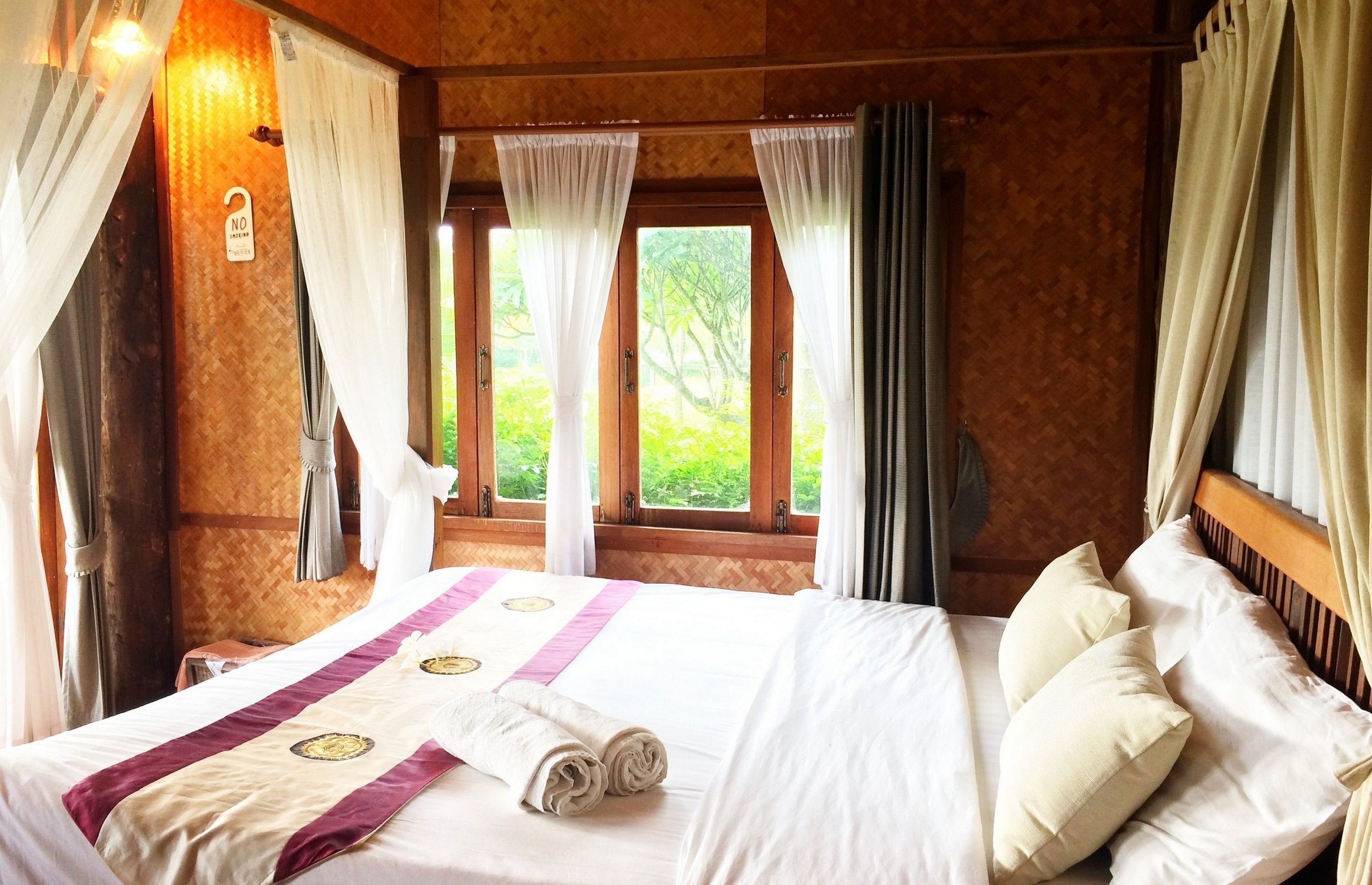 Una habitación de hotel con cama, cortinas, una ventana y vistas.
