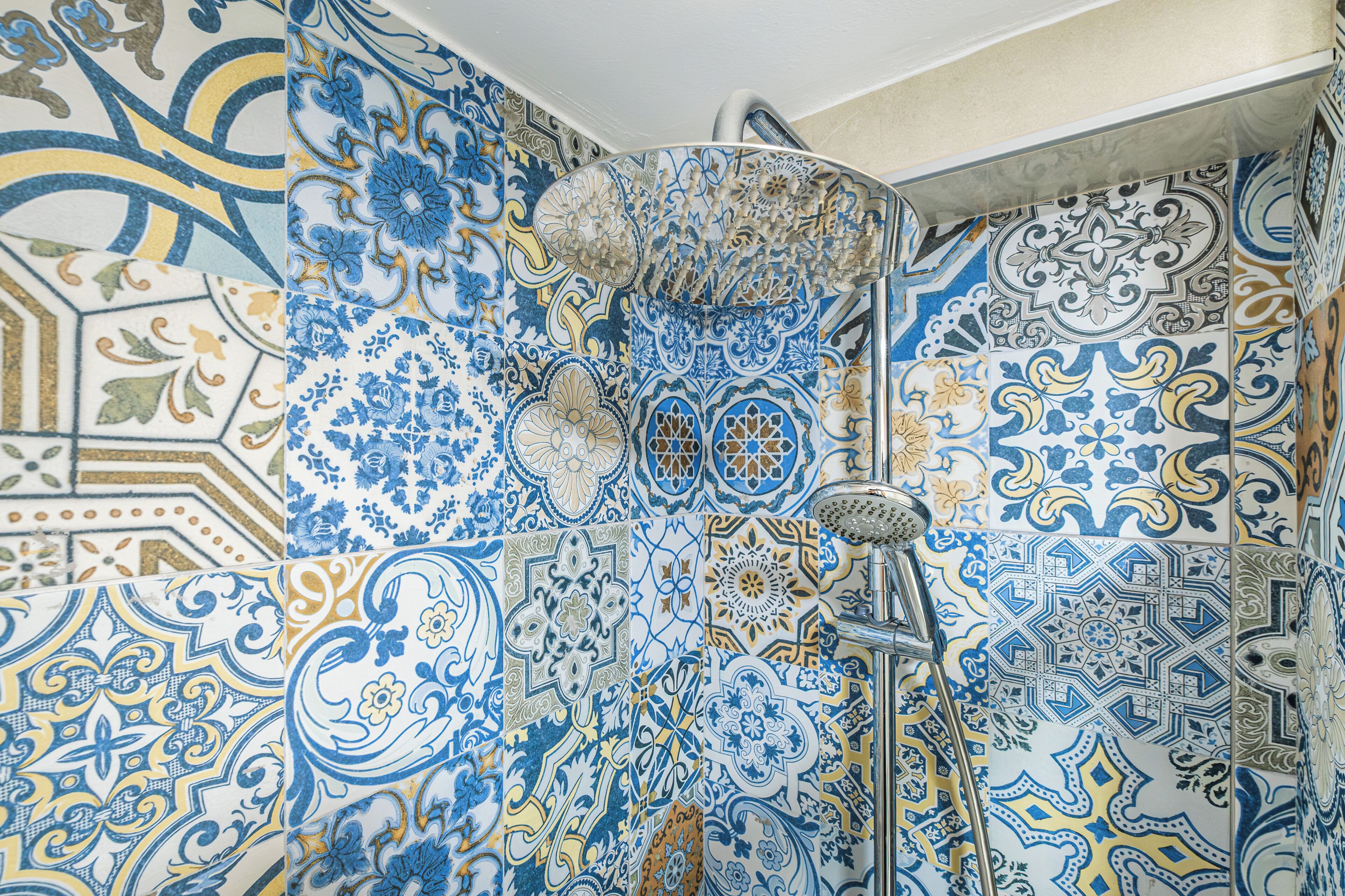 Un baño con elaborados diseños de azulejos y una zona de ducha.
