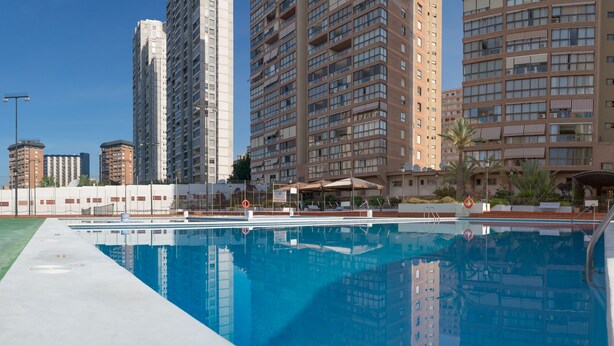 A swimming pool with high-rise buildings in the background. - Apartamentos Gemelos 2 - Beninter (Benidorm)