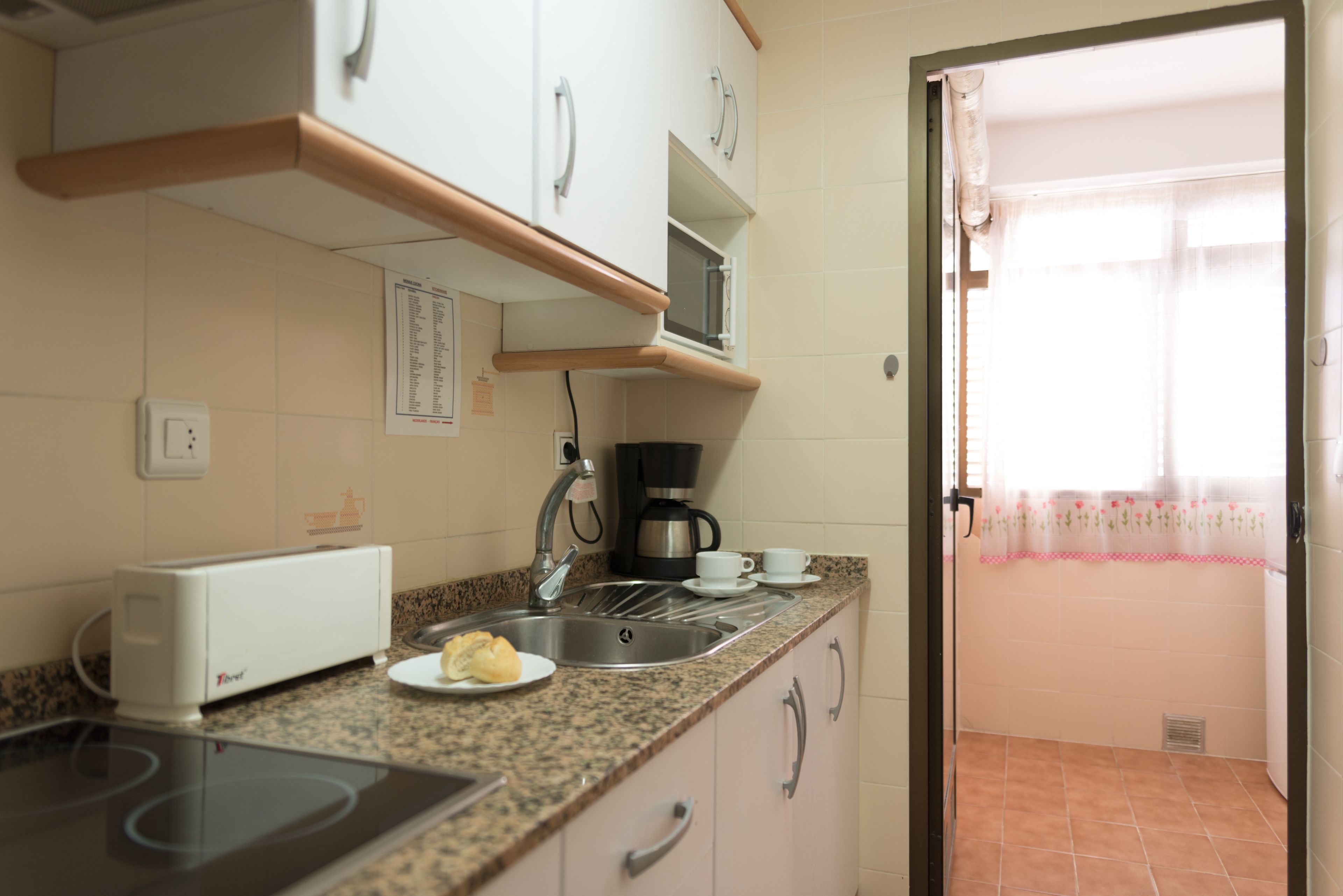 A kitchen with a toaster, sink, and coffee maker.