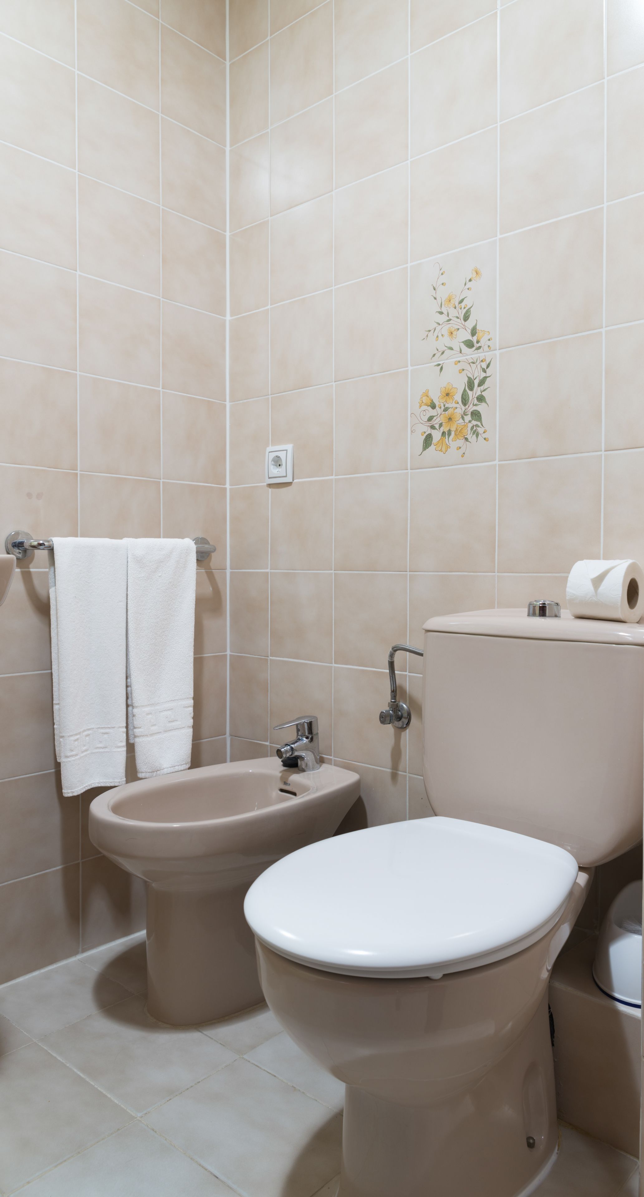 A bathroom with a bidet, toilet, and sink.