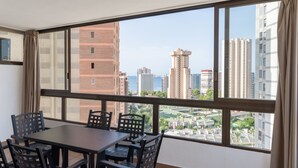 Una habitación con un ventanal grande, una mesa y sillas.