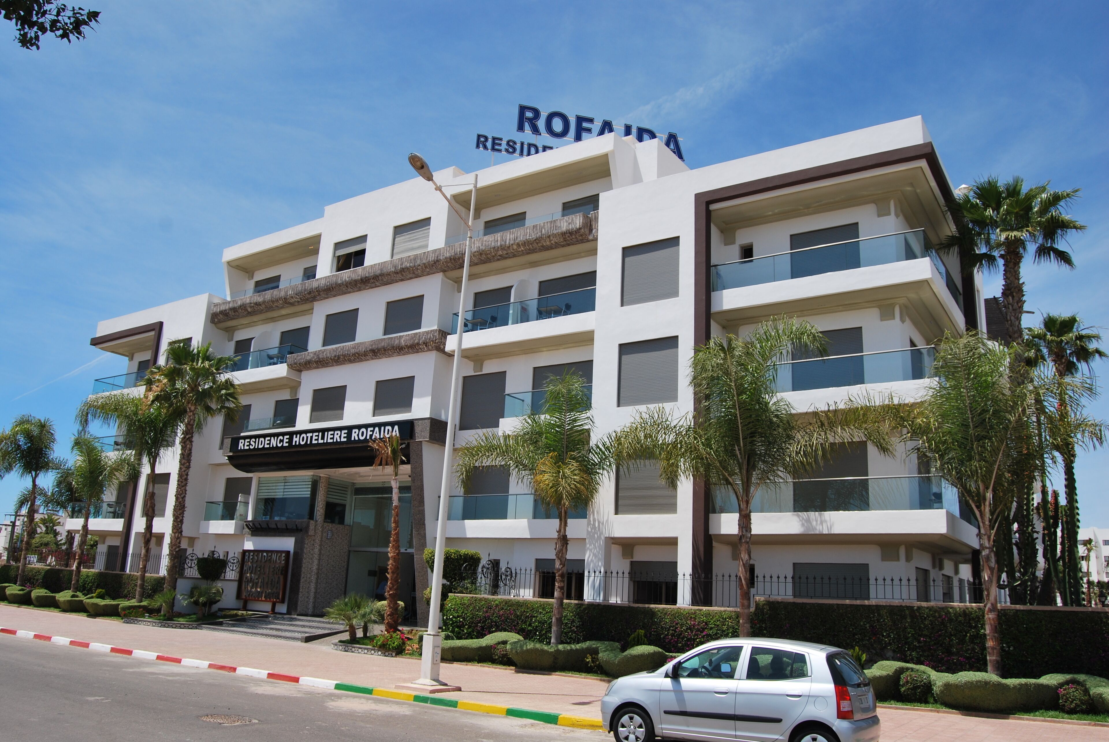 Un hotel de varios pisos con balcones y un letrero que dice "ROFAIRA RESIDENCE HOTELIERIE ROFAIRA".