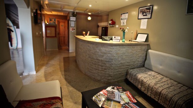 A reception area with a curved counter, a sofa, and a coffee table with magazines.