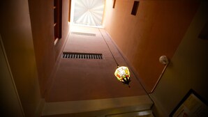 A corridor with a skylight, a vent, and a hanging light fixture.