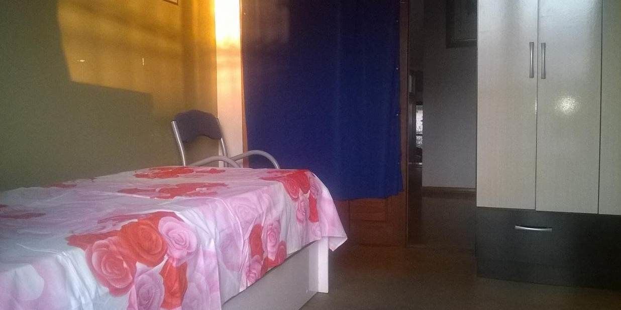 Une chambre à coucher avec un lit, une chaise et une armoire.