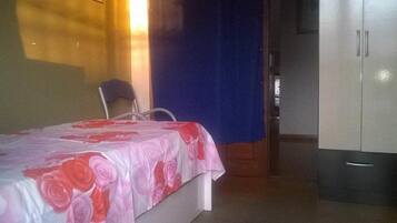 Une chambre à coucher avec un lit, une chaise et une armoire.