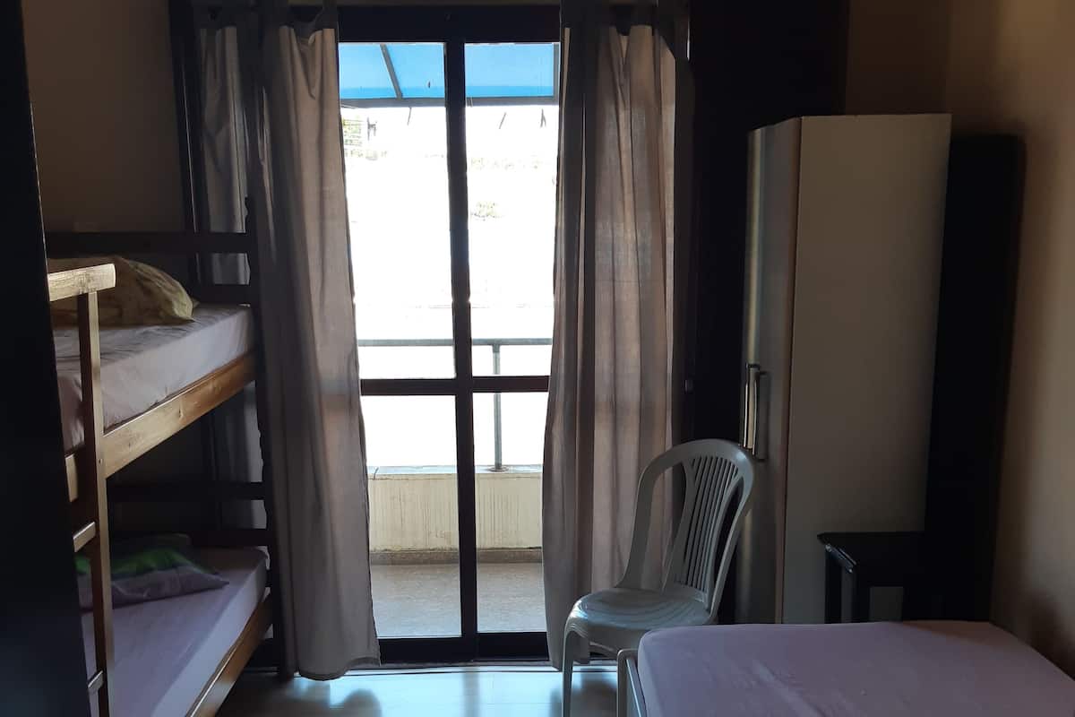 Une chambre avec des lits superposés, une chaise, un bureau et une armoire.