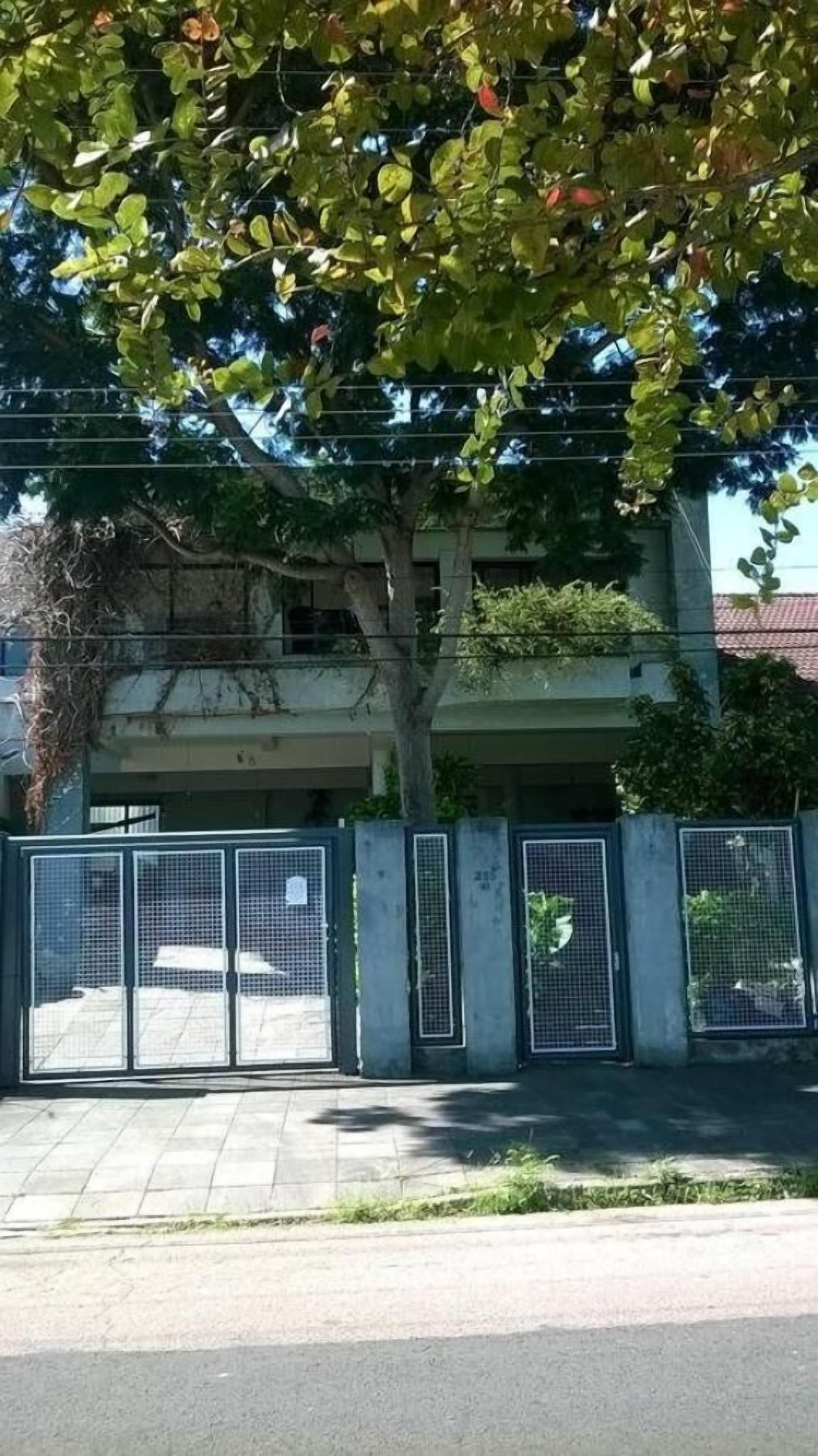 Un estacionamiento cerrado con un árbol al frente.