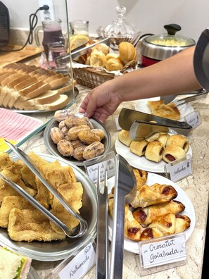 A buffet with various food items including pastries and sandwiches. - Pousada Canasvieiras (Florianópolis)