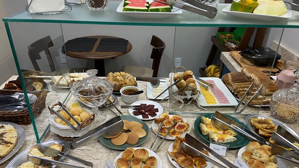 Un bufé con diversas opciones de comida, incluyendo pan, pasteles y frutas.