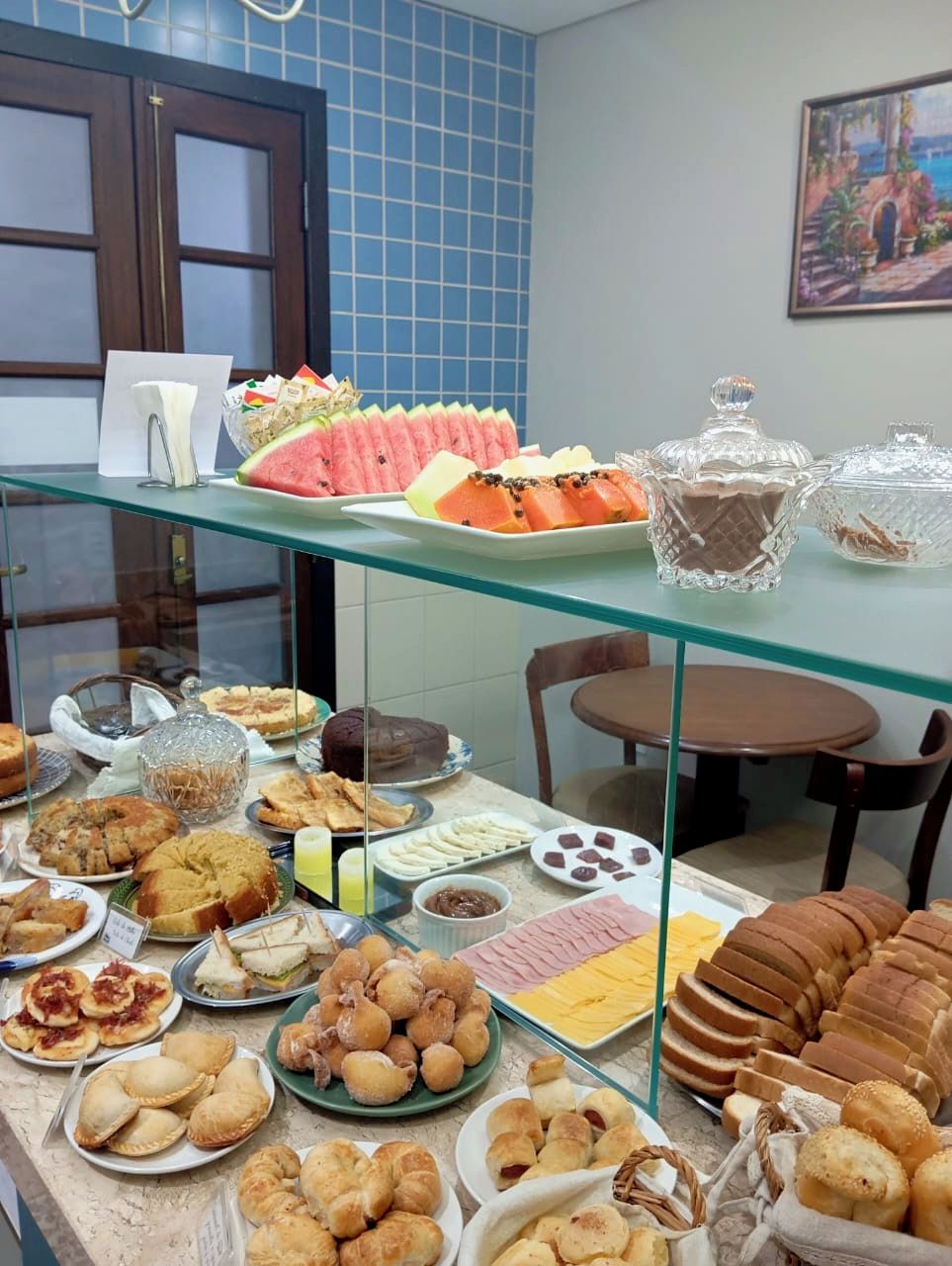 A buffet with various food items including pastries, sandwiches, and fruits.