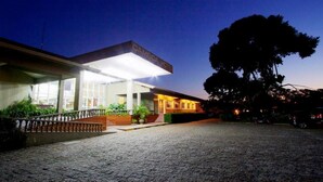 Un edificio moderno con un letrero que dice "CAMBODIA HOTEL" al anochecer.
