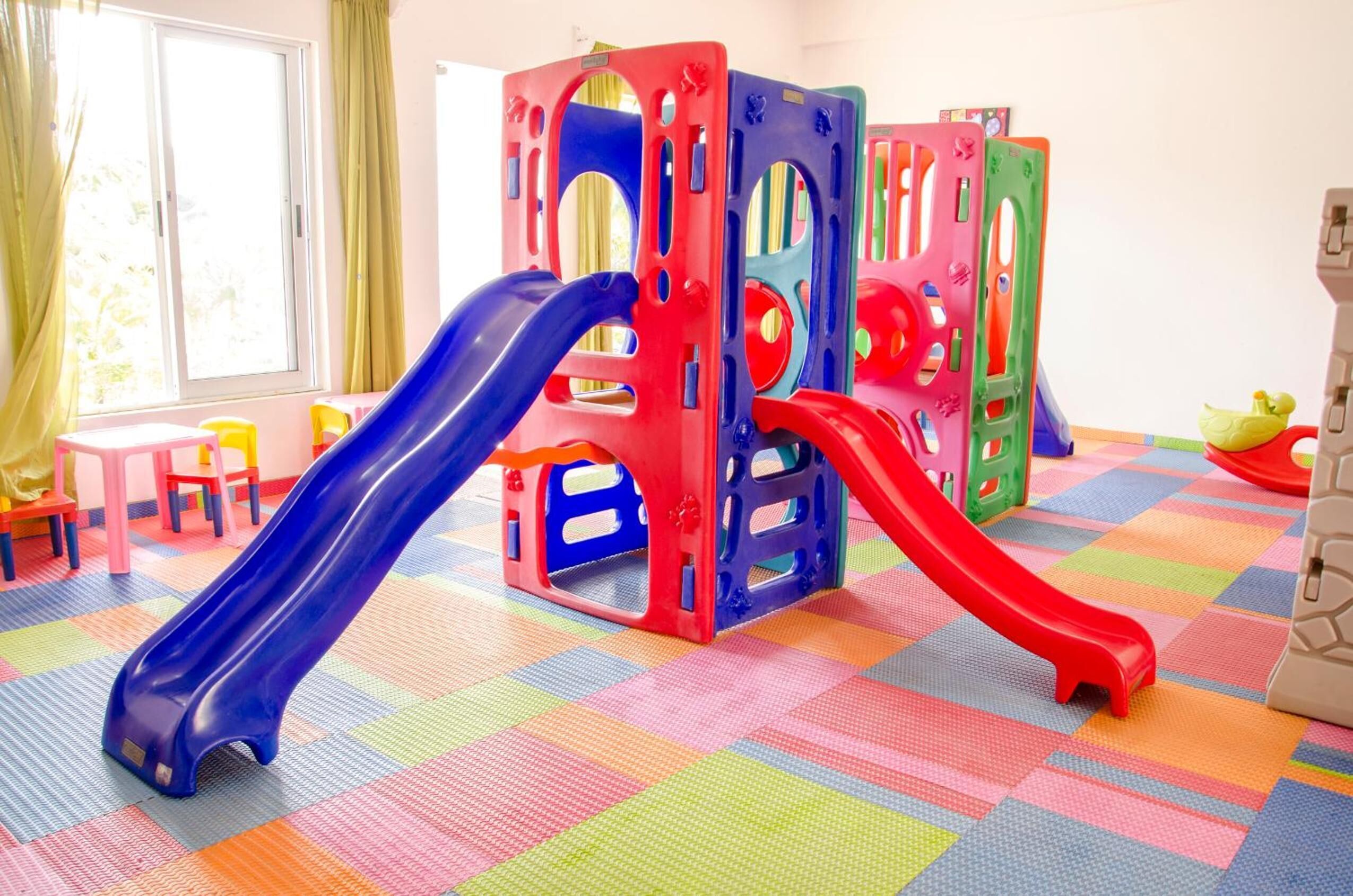 A play area with two slides and colorful play structures.