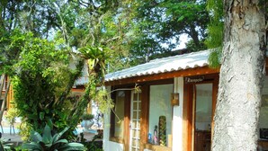 A small building with a sign reading "Recepção". - Pousada Náutilus (Ilhabela)