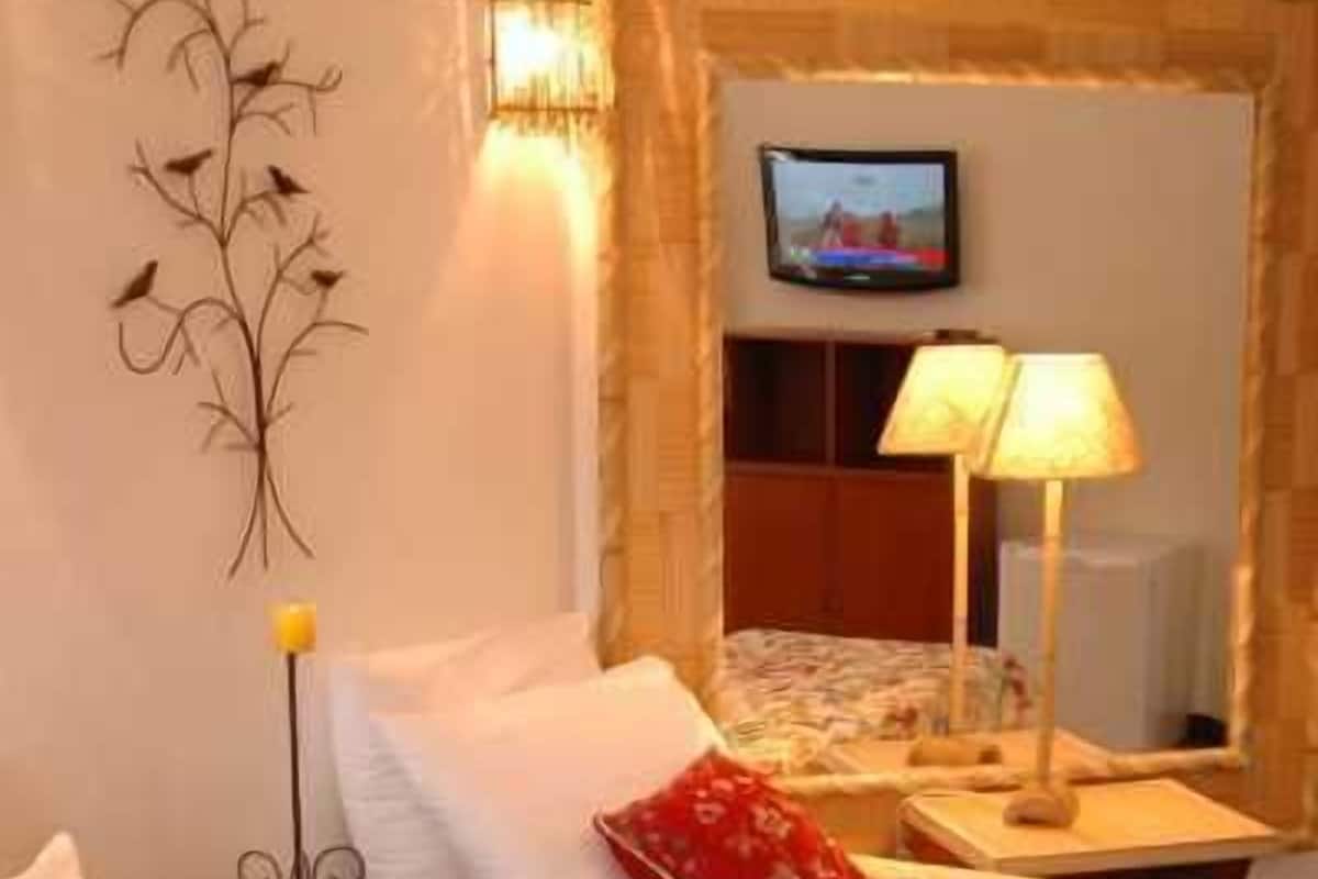 Habitación de hotel con dos camas, televisión y un adorno en la pared.