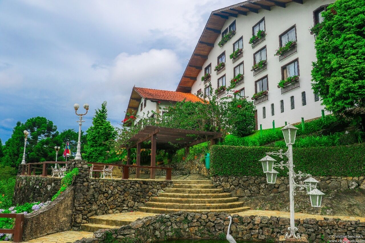Un edificio con una escalera de piedra que lleva a una pérgola de madera.