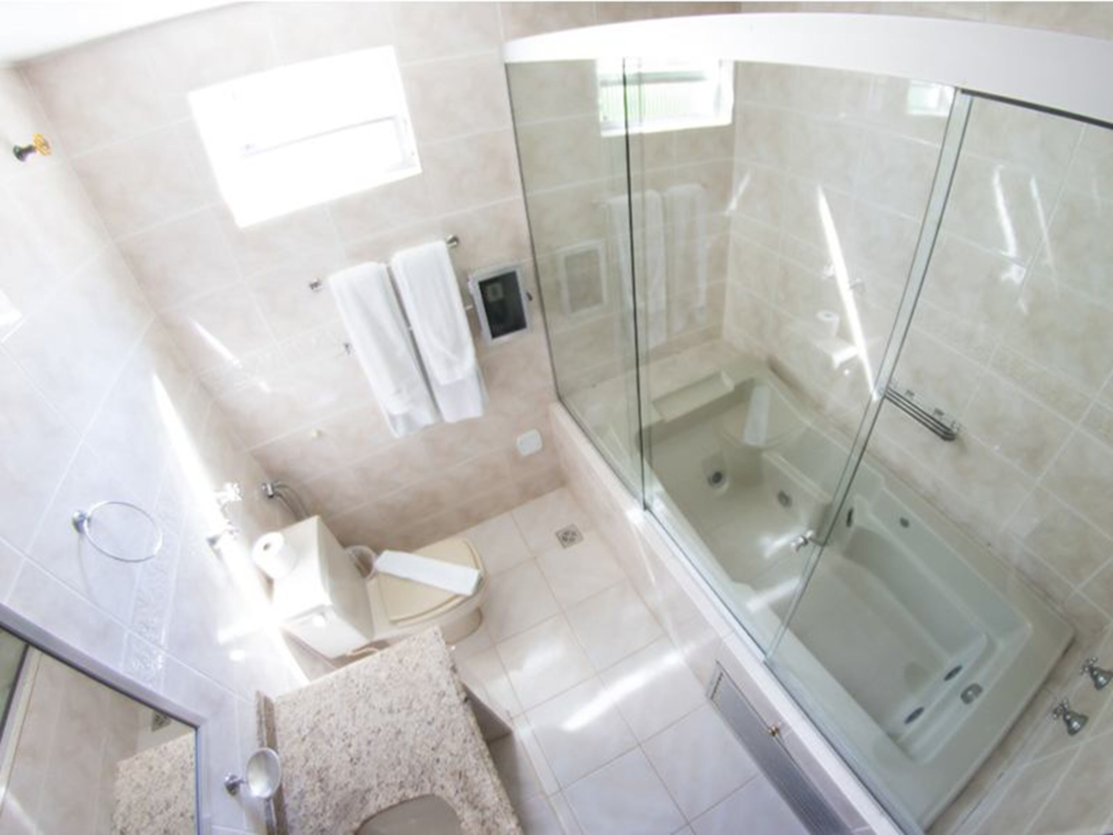 A modern bathroom with a glass-enclosed shower, a sink, and a toilet.