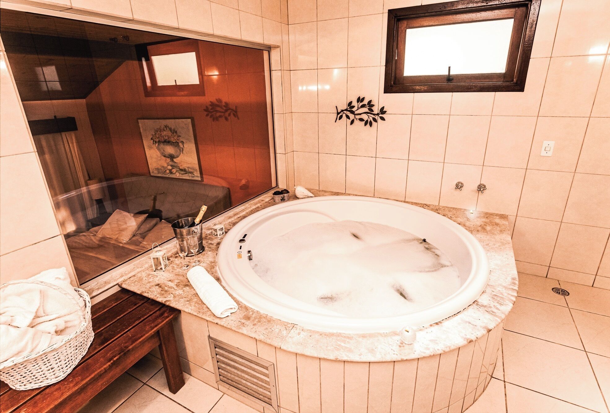 Une salle de bain avec une grande baignoire, un miroir, une fenêtre et un porte-serviettes.