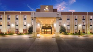 A Comfort Suites hotel entrance with a modern design, featuring a prominent sign, a well-lit entrance, and a parking lot. - Comfort Suites Rensselaer near Fair Oaks (Rensselaer)